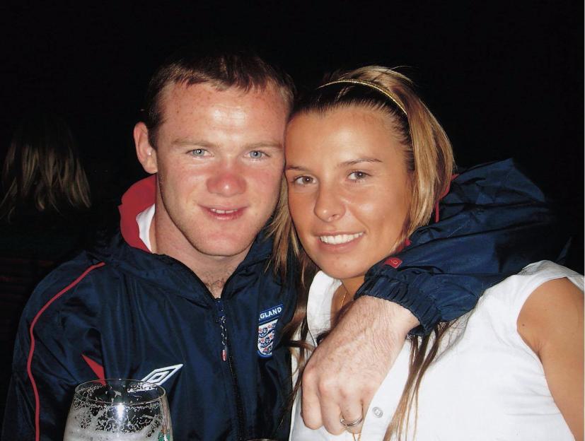 Wayne Rooney and Coleen McLoughlin smiling, with Rooney's arm around McLoughlin.