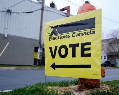 Yellow Elections Canada sign with arrow pointing left, indicating polling station.