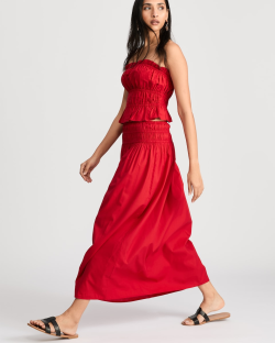 Woman in red smocked top and maxi skirt.