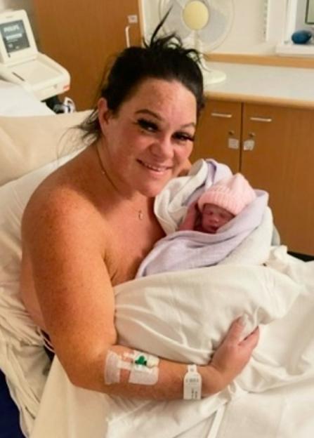 Stacey Sprason holding her infant Teraysa in a hospital bed.