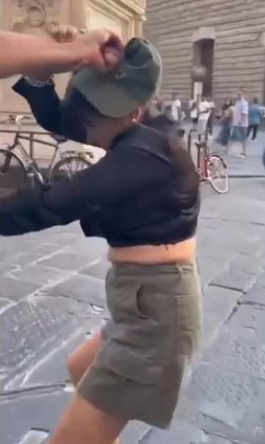 A man grabbing a woman by the hair.