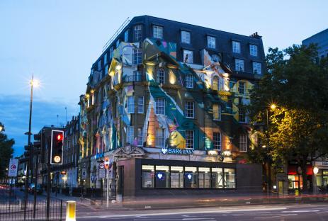 Megaro Hotel building at night with colorful artwork.