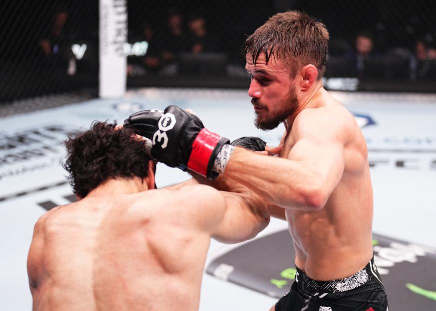 Muhammad Naimov of Tajikistan and Nathaniel Wood of England trade punches in a featherweight fight during the UFC 294 event.
