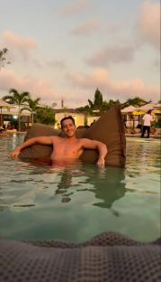 Man relaxing in a pool on a beanbag chair.