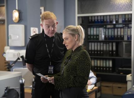 A police officer and a woman reviewing a document.