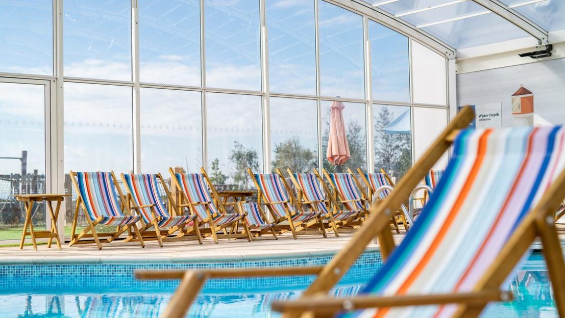 Deck chairs by an indoor pool at Mersea Island resort.
