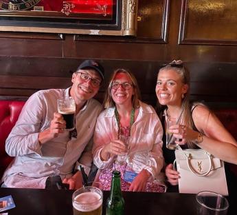 Three friends enjoying drinks at a pub.