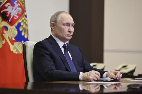 Vladimir Putin listening during a meeting.