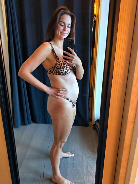 Woman in leopard-print bikini taking a selfie in a mirror.