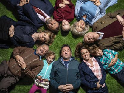 Cast photo of Not Going Out, lying on the grass in a circle.
