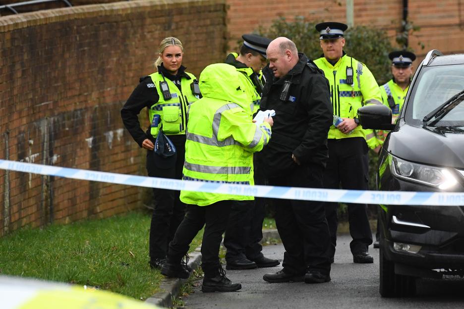 Emergency services, including police officers, at a murder scene.