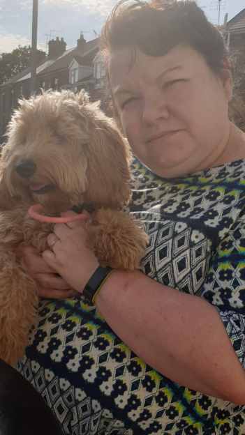 Woman holding a small dog.