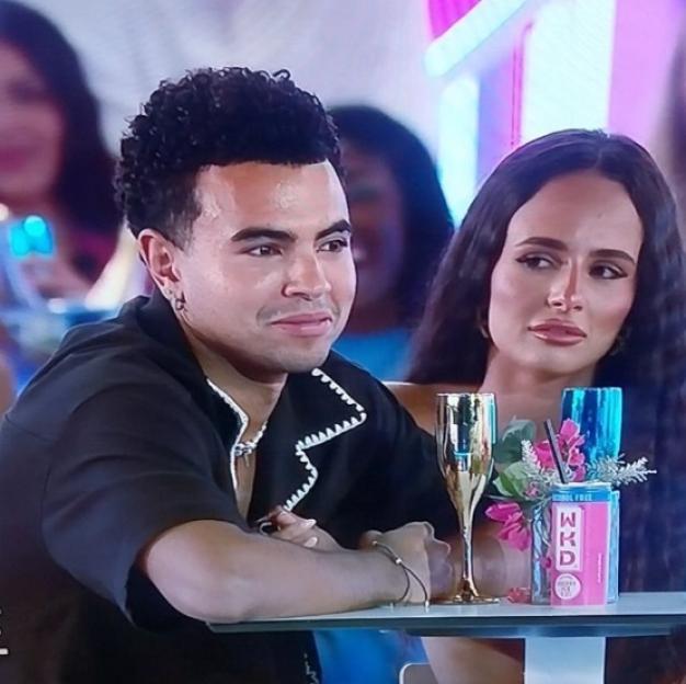 Screenshot of a man and woman sitting at a table together.