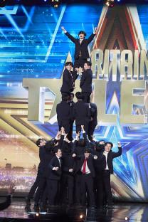 A group of men in suits forming a human pyramid on Britain's Got Talent.
