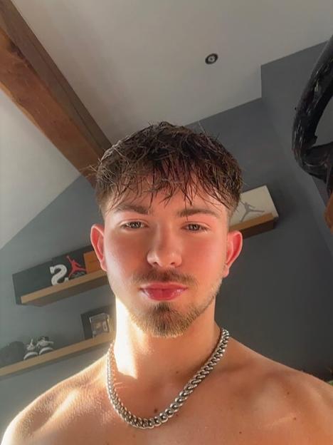 Close-up selfie of a young man with a silver chain necklace.