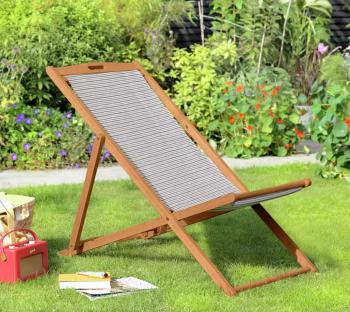 Wooden folding deck chair on a lawn.