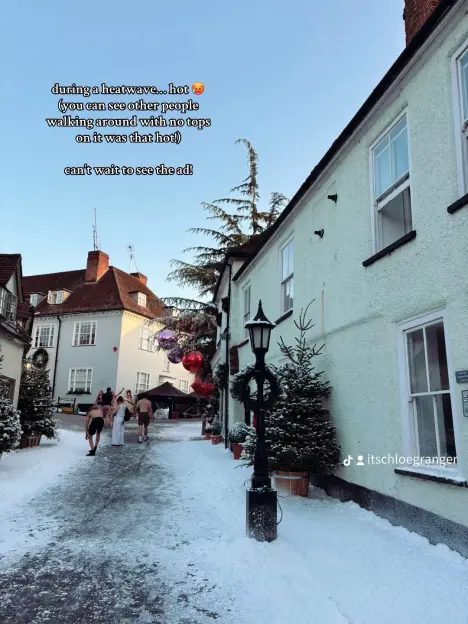 People in swimwear walking down a snow-covered street.