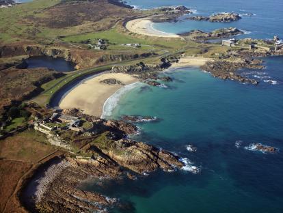 Aerial view of Corblets beach, surrounded by rugged rocks and calm blue seas.
