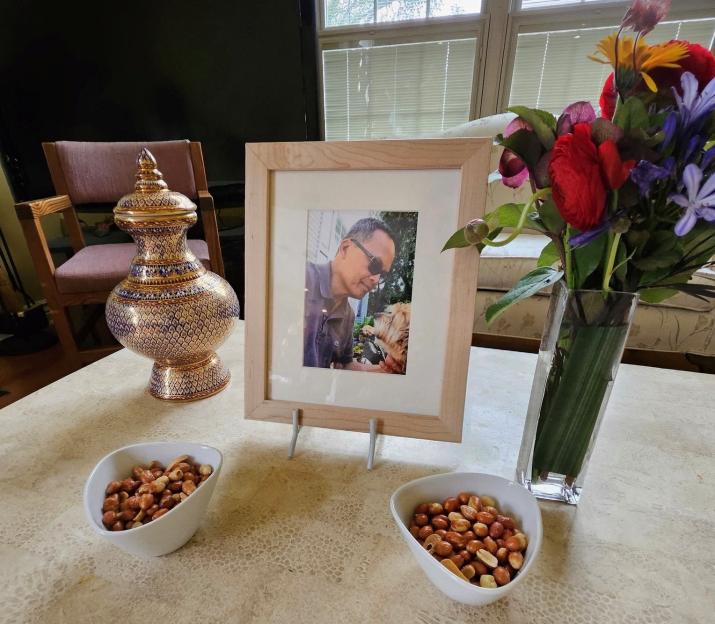 Memorial display with a framed photo of Thongbue "Bue" Wongbandue and his dog.