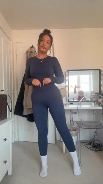 Woman in a dark blue long-sleeve top and leggings.