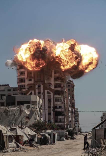Large explosions and smoke rising above buildings in Gaza City.