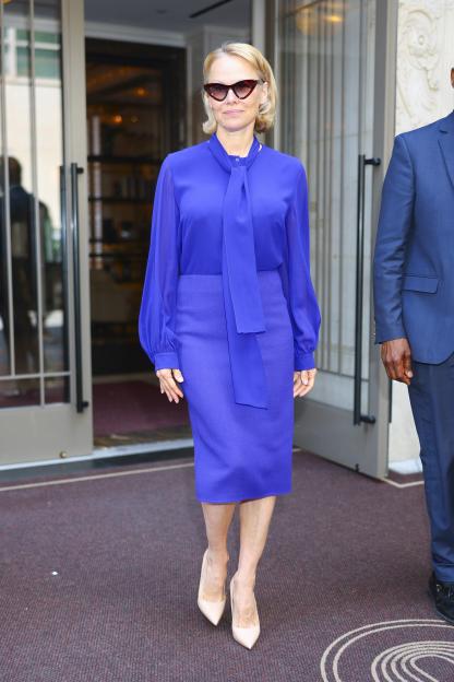 Pamela Anderson in Midtown, wearing a purple suit and sunglasses.