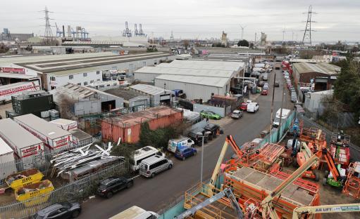 Aerial view of an industrial estate with parked vehicles and construction equipment.