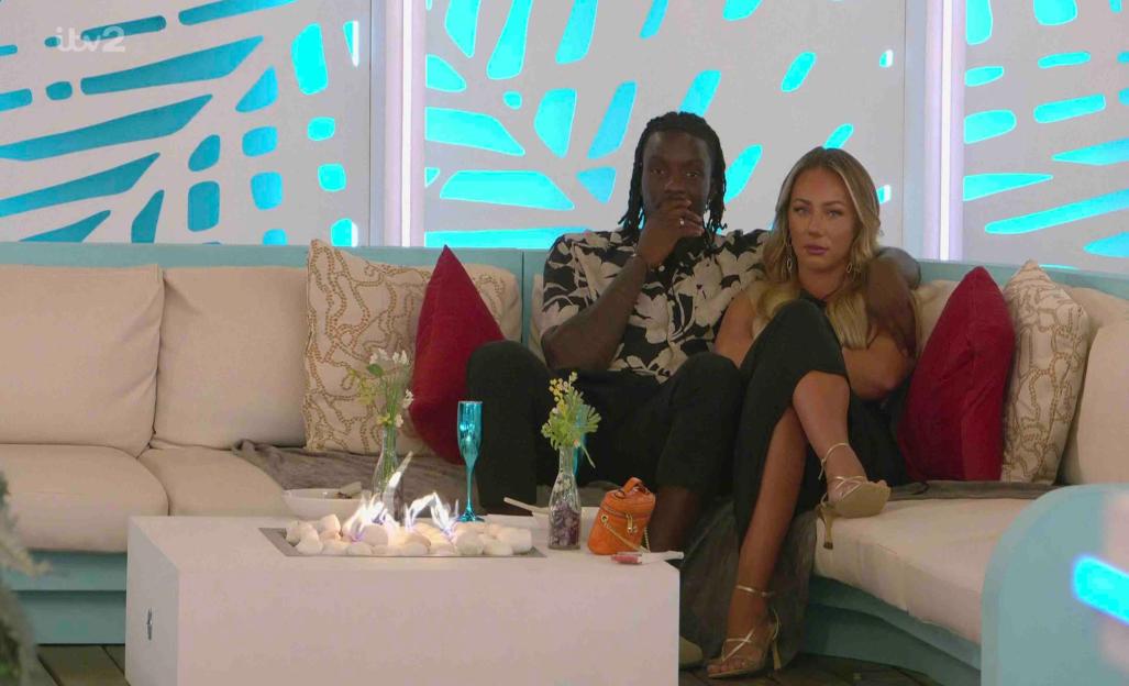 Meg and Dejon from Love Island sitting on a couch.