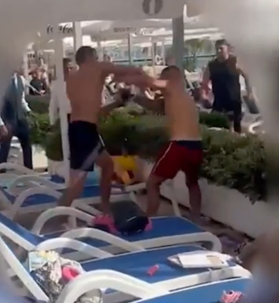 Two men fighting near a pool.