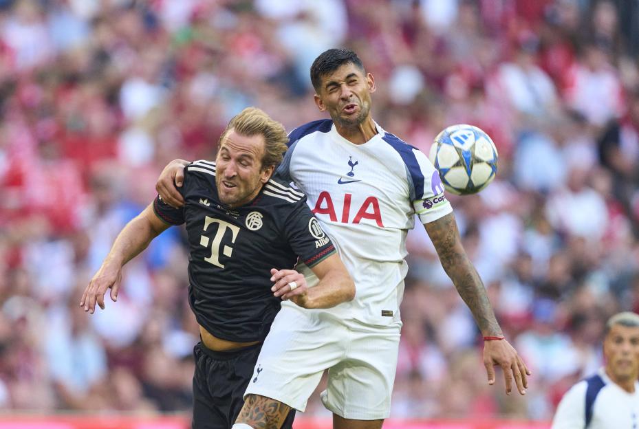 Harry Kane of FC Bayern München and Cristian Romero of Tottenham vying for the ball during a soccer match.