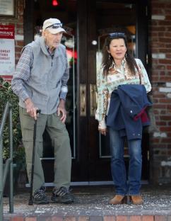 Older man and woman standing outside a restaurant.
