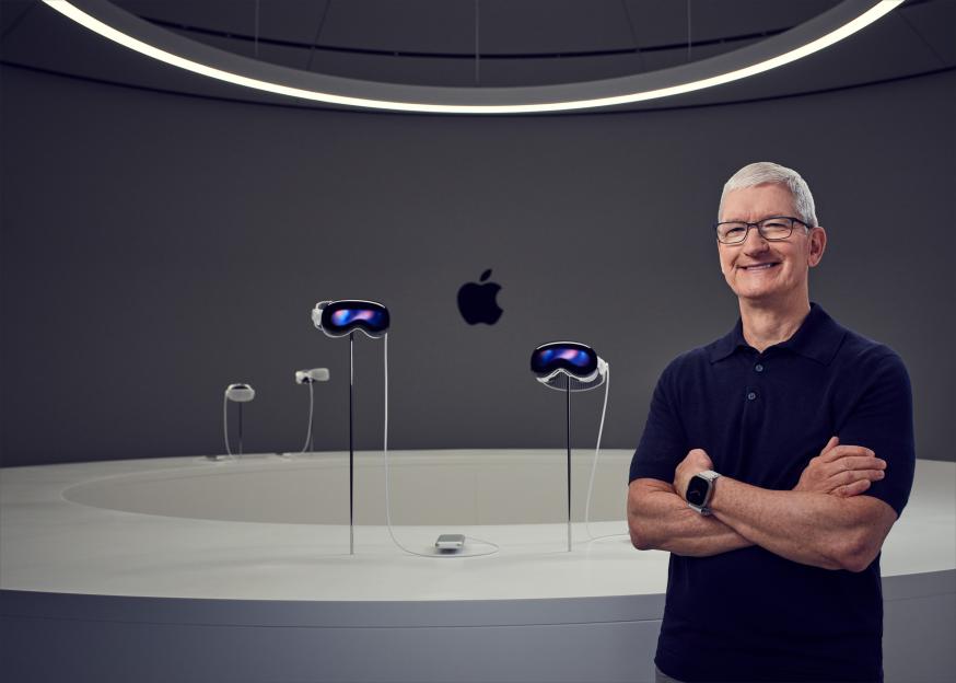 Tim Cook standing with Apple Vision Pro headsets.