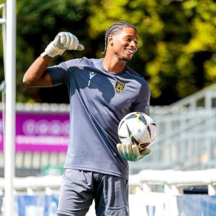 Soccer goalie holding a ball and celebrating.