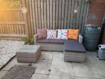 Garden sofa set with patterned cushions.