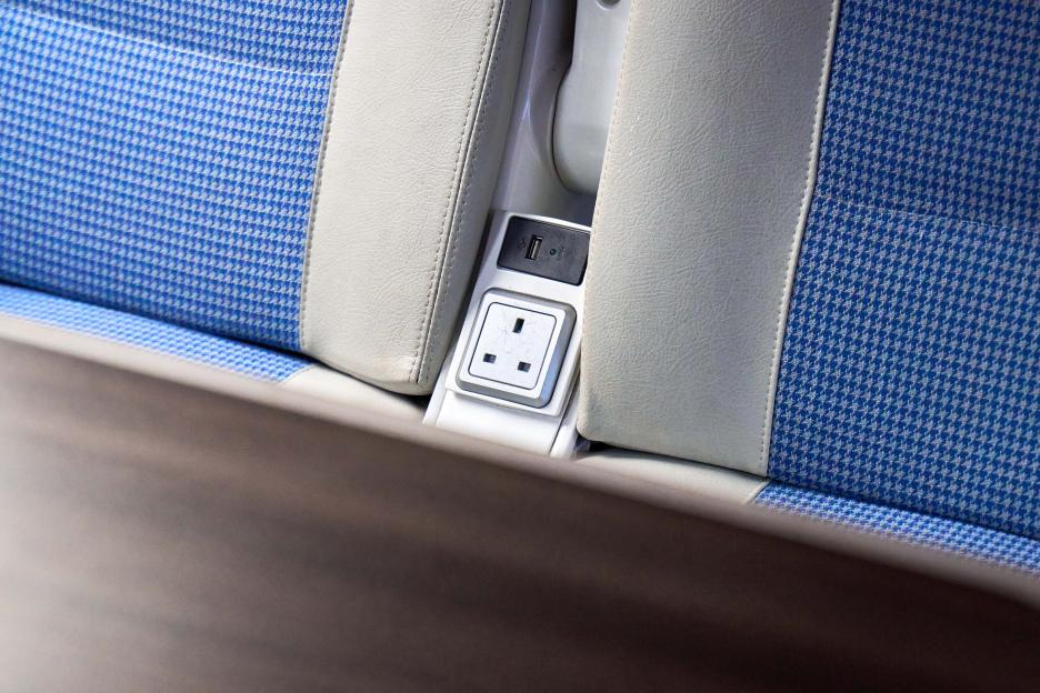 Power outlet and USB port on a train seat.