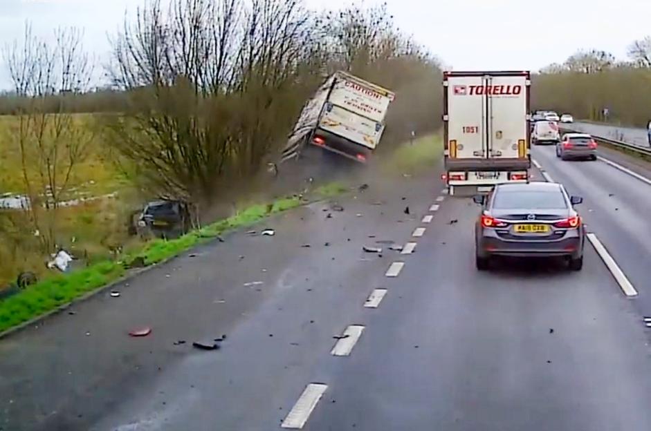 Dashcam footage shows a box van overturned in a ditch after ploughing into parked cars, with vehicle debris scattered across the road.
