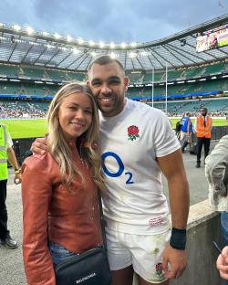 Photo of a man and woman at a rugby stadium.