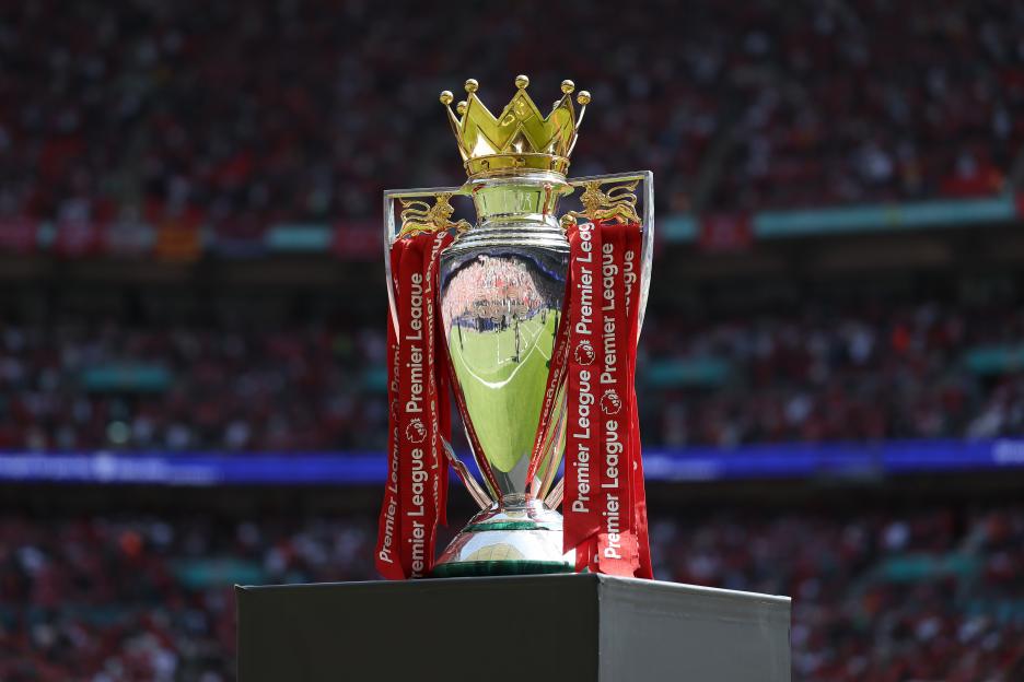 Premier League trophy on display at a stadium.