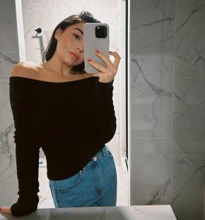 Woman taking a selfie in a bathroom mirror after losing weight with Ozempic.