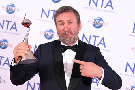Lee Mack holding a National Television Award.