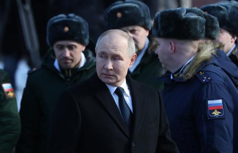 Vladimir Putin at a wreath-laying ceremony with military officers.