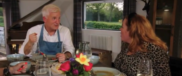 Screenshot of two people eating at a table.