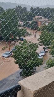 Cars submerged in floodwaters on a street.