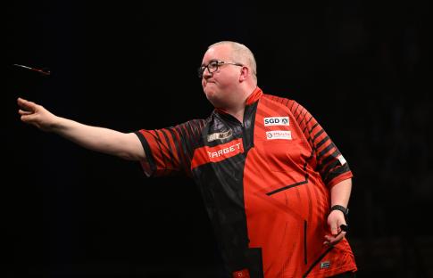Stephen Bunting throwing a dart during a darts match.