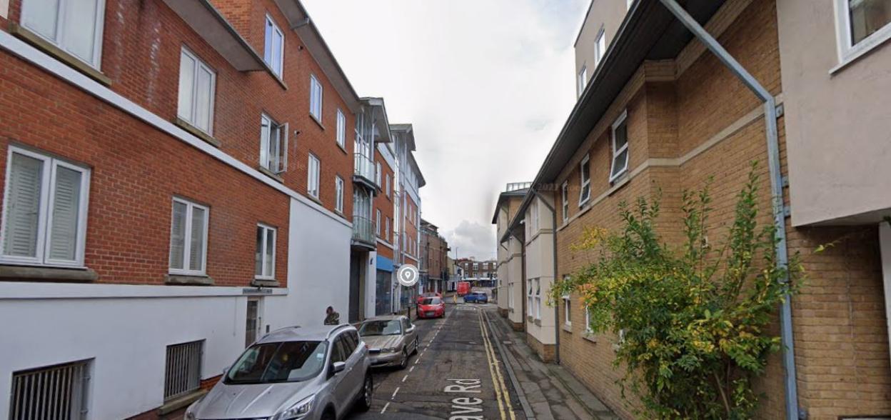 Street view of Grave Road with brick buildings and parked cars.