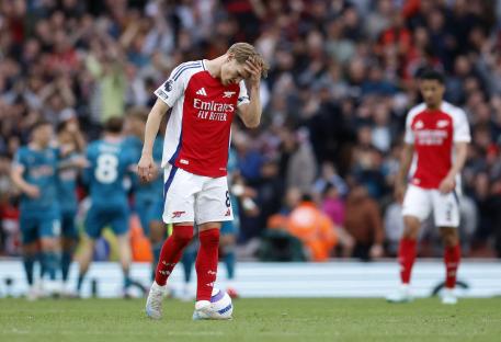 Martin Odegaard looking dejected on a soccer field.
