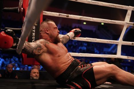 Eddie Hall leaning against the ropes in a boxing ring.
