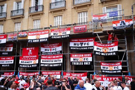 Manchester United supporters' flags on scaffolding.