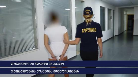 A handcuffed woman escorted by a police officer.