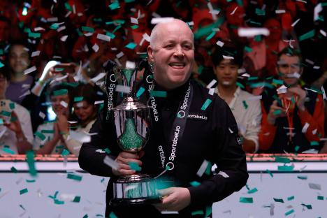 John Higgins holding a trophy amidst confetti.